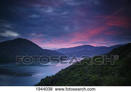 Stock Photo - Mountains Along The Coastline Under A Red Sky At Sunset; Havelock South Island New Zealand. Fotosearch