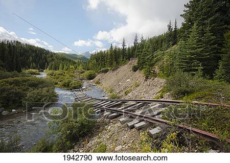 Stock Image - Old Railway Tracks Hanging Above A Creek; Cadomin Alberta Canada. Fotosearch