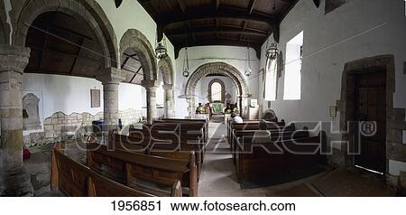 Stock Image - people sitting in the wooden pews of st. john the baptist church; edlingham alnwick northumberland england. Fotosearch