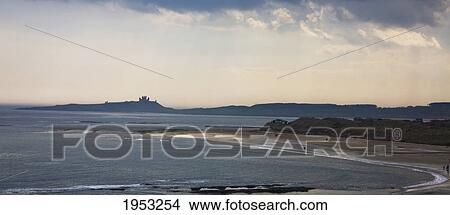 Picture - people walking on the beach at sunset; newton-by-the-sea northumberland englanc. Fotosearch