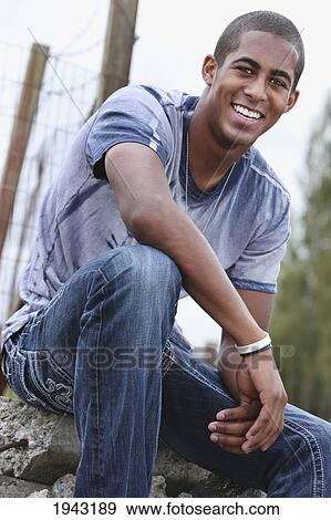 Portrait Of A Teenage Boy Sitting On Rocks; Troutdale Oregon United States Of America View Large Photo Image Stock Photo - Portrait Of A Teenage Boy Sitting On Rocks; Troutdale Oregon United States Of America. Fotosearch