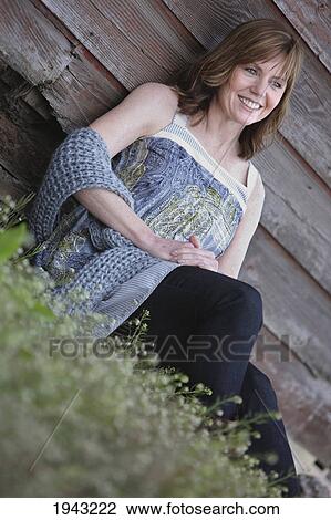 Portrait Of A Woman Sitting Against A Barn; Troutdale Oregon United States Of America View Large Photo Image Stock Image - Portrait Of A Woman Sitting Against A Barn; Troutdale Oregon United States Of America. Fotosearch
