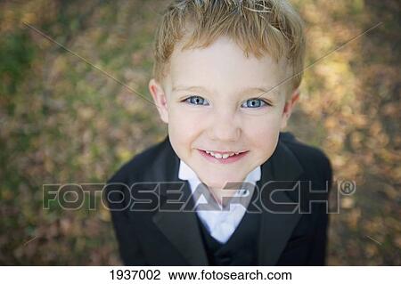 Stock Image - Portrait Of A Young Boy Wearing A Black Suit; Edmonton Alberta Canada. Fotosearch