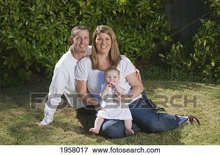portrait of a young couple with a baby on the grass; moraga california united states of america View Large Photo Image Stock Photo - portrait of a young couple with a baby on the grass; moraga california united states of america. Fotosearch