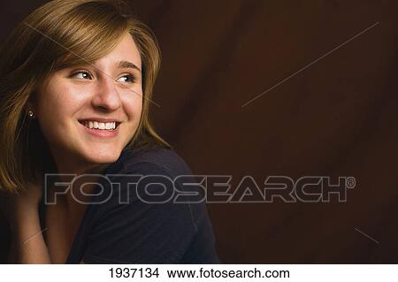 Portrait Of A Young Woman With A Brown Background View Large Photo Image Picture - Portrait Of A Young Woman With A Brown Background. Fotosearch