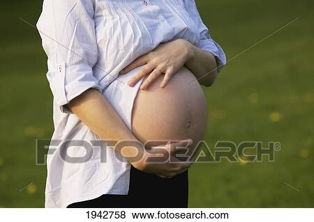 Stock Photo - Pregnant Woman Holding Her Bare Belly; Dublin Ireland. Fotosearch
