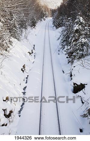 Stock Photograph - railroad tracks covered in snow in the winter; orford quebec canada. Fotosearch