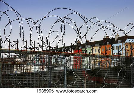 Stock Photography - Row Houses Seen From Behind A Barbed Wire Fence; Bristol England. Fotosearch