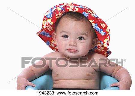 Stock Image - Shirtless Baby Boy Sits In A Blue Ring Wearing A Bathing Suit And Hawaiian Hat; Troutdale Oregon United States Of America. Fotosearch