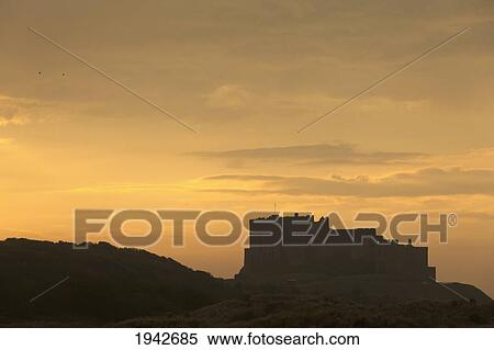 Stock Photography - Silhouette Of A Building At Sunset; Bamburgh Northumberland England. Fotosearch