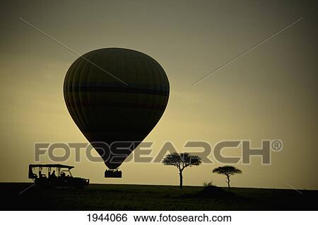 Stock Photograph - Silhouette Of A Cart Hot Air Balloon And Trees At Sunset; Masai Mara Kenya. Fotosearch