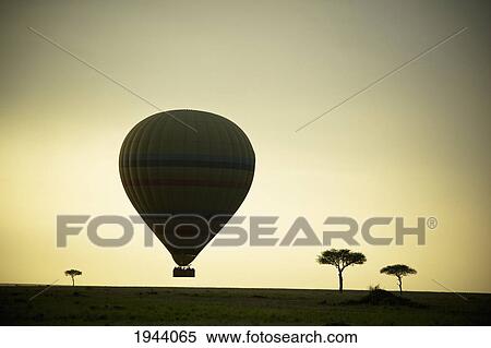 Stock Photography - Silhouette Of A Hot Air Balloon Just Off The Ground At Dusk; Masai Mara Kenya. Fotosearch