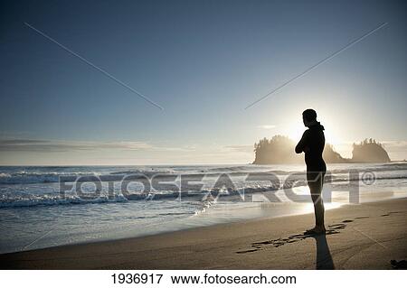 Silhouette Of A Person Standing On A Beach Looking Out Over The Ocean; La Push Washington United States Of America View Large Photo Image Stock Photo - Silhouette Of A Person Standing On A Beach Looking Out Over The Ocean; La Push Washington United States Of America. Fotosearch
