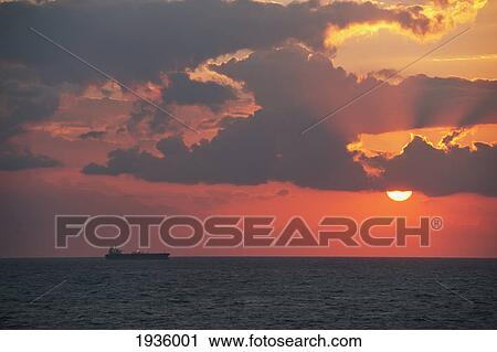 Stock Image - Silhouette Of Cruise Ship As Sunsets On East China Sea; China. Fotosearch