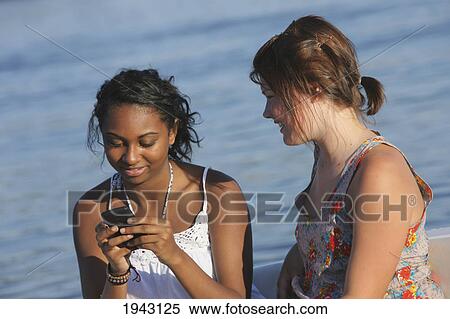 Stock Photography - Teenage Girls Playing With A Cell Phone; Troutdale Oregon United States Of America. Fotosearch