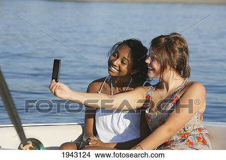 Picture - Teenage Girls Taking A Picture Of Themselves With A Cell Phone; Troutdale Oregon United States Of America. Fotosearch