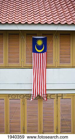Stock Photo - The Malaysian Flag Hangs Over Shutters On A Building; Penang Malaysia. Fotosearch