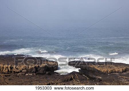 Stock Image - the ocean crashing against the flat rock on the coast; bamburgh northumberland england. Fotosearch