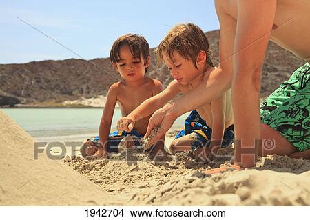 Picture - Three Boys Play In The Sand At The Water's Edge At Los Islotes National Marine Park Espiritu Santo Island; La Paz Baja California Mexico. Fotosearch