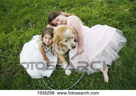 Two Sisters In Dresses Hug Their Rescue Dog Outdoors; Duncan, Vancouver Island, British Columbia, Canada View Large Photo Image Stock Photo - Two Sisters In Dresses Hug Their Rescue Dog Outdoors; Duncan, Vancouver Island, British Columbia, Canada. Fotosearch