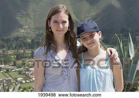 Stock Photo - Two Sisters Standing Together With Sacred Valley Below Them; Sacred Valley Peru. Fotosearch