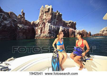 Two Tourists Sitting On The Edge Of A Boat With Snorkeling Gear At Los Islotes National Marine Park Espiritu Santo Island; La Paz Baja California Mexico View Large Photo Image Stock Image - Two Tourists Sitting On The Edge Of A Boat With Snorkeling Gear At Los Islotes National Marine Park Espiritu Santo Island; La Paz Baja California Mexico. Fotosearch