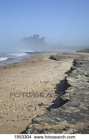 Picture - view of bamburgh castle through the fog from the beach; bamburgh northumberland england. Fotosearch