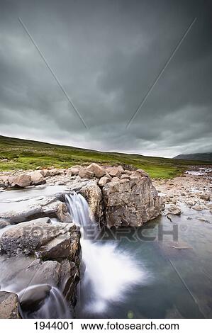 Stock Image - Water Cascading Over The Rocks Along The Shoreline; Iceland. Fotosearch