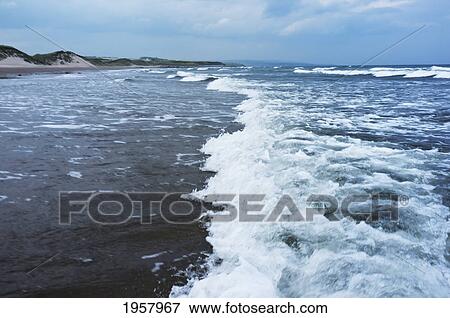 Stock Photo - waves of the ocean crashing into the shore; northumberland england. Fotosearch