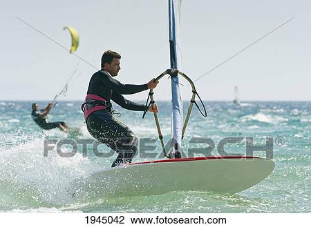Stock Image - windsurfers in the water off punta paloma; tarifa cadiz andalusia spain. Fotosearch