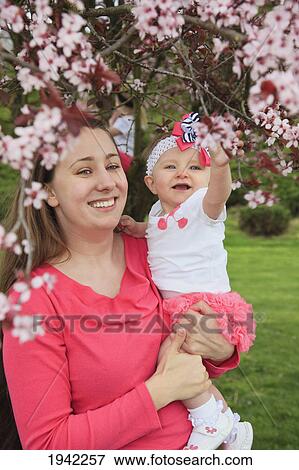 Stock Photo - Woman Holding Her Daughter In The Park In Spring; Portland Oregon. Fotosearch
