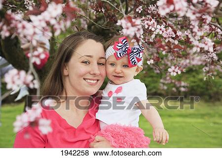 Stock Photo - Woman Holding Her Daughter In The Park In Spring; Portland Oregon. Fotosearch