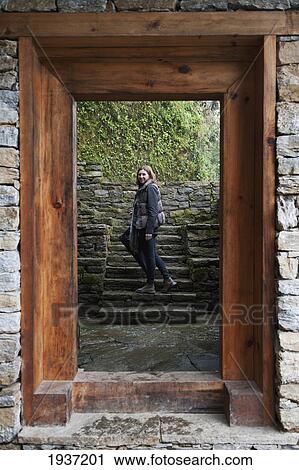 Stock Image - Woman Seen Through Doorway Of Trongsa Museum; Trongsa Bhutan. Fotosearch