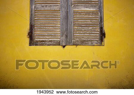 Stock Image - Wooden Shutters On A Yellow Wall; Dakar Senegal. Fotosearch