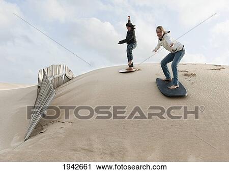 Young Women Slide On Boards Over The Punta Paloma Sand Dunes; Tarifa Cadiz Andalusia Spain View Large Photo Image Stock Image - Young Women Slide On Boards Over The Punta Paloma Sand Dunes; Tarifa Cadiz Andalusia Spain. Fotosearch