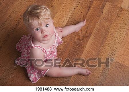 a baby girl sits on a hardwood floor; alberta canada View Large Photo Image Stock Photo - a baby girl sits on a hardwood floor; alberta canada. Fotosearch