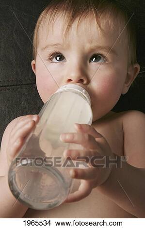 a baby laying on it's back drinking milk from a bottle; edmonton alberta canada View Large Photo Image Picture - a baby laying on it's back drinking milk from a bottle; edmonton alberta canada. Fotosearch