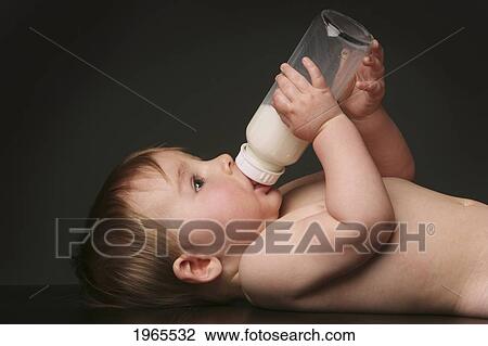 Stock Image - a baby laying on it's back drinking milk from a bottle; edmonton alberta canada. Fotosearch