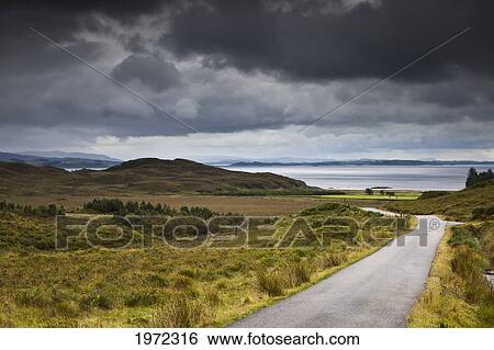 Stock Photograph - a country road through a hilly landscape along the coast; ardnamurchan argyl scotland. Fotosearch