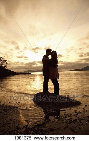 Stock Photography - a couple kissing on the water's edge; bellingham washington united states of america. Fotosearch