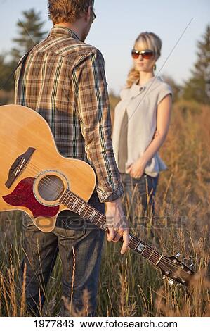 a couple standing in a field with a guitar; edmonton alberta canada View Large Photo Image Stock Image - a couple standing in a field with a guitar; edmonton alberta canada. Fotosearch