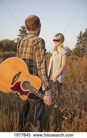 a couple standing in a field with a guitar; edmonton alberta canada View Large Photo Image Stock Photography - a couple standing in a field with a guitar; edmonton alberta canada. Fotosearch