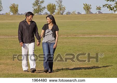 a couple walking and talking in a park; edmonton, alberta, canada View Large Photo Image Stock Image - a couple walking and talking in a park; edmonton, alberta, canada. Fotosearch