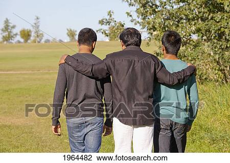 Stock Image - a father and two sons walking in a park; edmonton, alberta, canada. Fotosearch