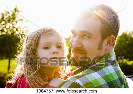 a father holds his daughter in the sunlight; bellingham washington united states of america View Large Photo Image Stock Photo - a father holds his daughter in the sunlight; bellingham washington united states of america. Fotosearch