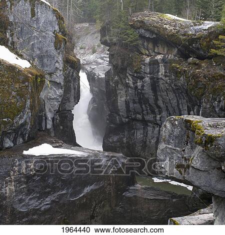 Stock Image - a frozen waterfall between large rocks in jasper national park; alberta, canada. Fotosearch