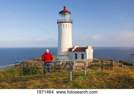 a man stands looking out over the ocean beside north head light; ilwaco washington united states of america View Large Photo Image Picture - a man stands looking out over the ocean beside north head light; ilwaco washington united states of america. Fotosearch