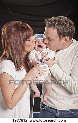 a mother and father kiss a crying newborn baby; edmonton alberta canada View Large Photo Image Stock Image - a mother and father kiss a crying newborn baby; edmonton alberta canada. Fotosearch