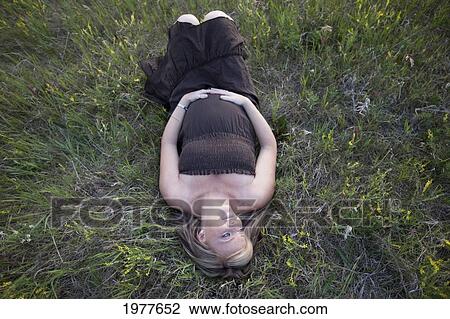 a pregnant woman lays on her back on the grass; edmonton alberta canada View Large Photo Image Stock Image - a pregnant woman lays on her back on the grass; edmonton alberta canada. Fotosearch