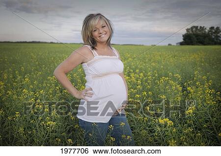 a pregnant woman standing in a field of wildflowers; edmonton alberta canada View Large Photo Image Stock Photograph - a pregnant woman standing in a field of wildflowers; edmonton alberta canada. Fotosearch
